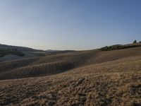 an image of a beautiful day in the hills with no clouds in the sky while someone has fallen grass and walks