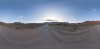 a 360 - camera image of a dirt road in the desert with mountains in the distance