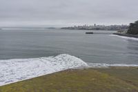 a lone surfer takes off for the waves to pass by a jetty out to sea