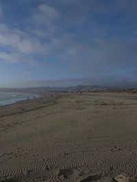 two surfers are on the beach in the sand near the water with waves coming up