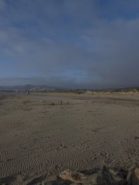 two surfers are on the beach in the sand near the water with waves coming up