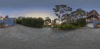 three houses are in a surreally designed photo while the sun is setting over the trees