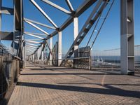 a pier with lots of water and a bridge for pedestrians to cross across it to get out