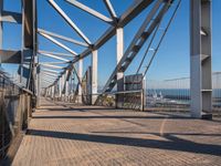 a pier with lots of water and a bridge for pedestrians to cross across it to get out