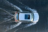 an suv driving through water at high speeds in the ocean with its top view open