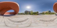 a 360 - view of three circular chairs in a park near a building, each sitting on an adjacent wall