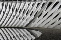 a black and white photo of a fountain by itself with strips of thinness on the outside