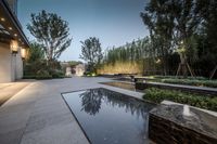 a modern outdoor living and swimming area with a reflection in the pool and a few steps