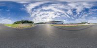 a fisheye view showing a winding road and a building from the inside out on a sunny day