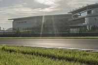 the sun shining over an airport with multiple runways and a street with traffic lights at the top of the road