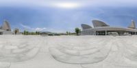 an empty, concrete building with curved shapes on the ground in a circle view from a fish - eye lens