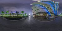 an outside view of a large building at night with lights in it's center