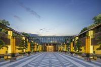 the courtyard of a large hotel with plants, trees and benches in the walkways