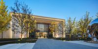 a building has been designed and lit up with lights on its exterior, surrounded by trees