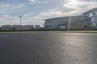 the empty street is lined with the grass and buildings on a sunny day in the city