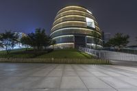 a large building with a small walkway between it and the sky in the background at night