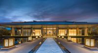 the house is lit up at night with the sky in the background as well as water and lighting