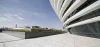 a view of an architectural building from the outside on a sunny day with some clouds in the background