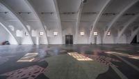 an open empty room with two tables, a chair, and floor tile designs on the ground