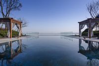 pool in the middle of a large open space with outdoor shower area in the background