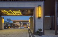 a modern building with a sign hanging from it's roof entrance into a courtyard