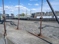 the swing is chained to a pole near the river bank and the city of hamburg