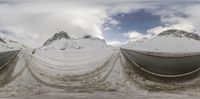 snow covers are all over the mountain on the slope, in the foreground is the road