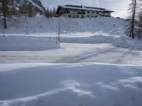 an outdoor view of a resort during the day in the snow, with a slope to the left