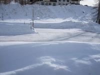 an outdoor view of a resort during the day in the snow, with a slope to the left