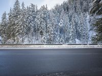 a road is covered in snow and trees on the side of it in winter time