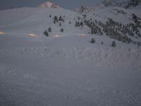 a man skiing down a snow covered mountain on a trail with a lodge in the distance