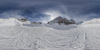 a mountain range covered in snow with lots of snow on the ground and some tracks