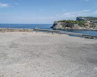 a paved road beside some large boats and a bridge with a bridge to the water