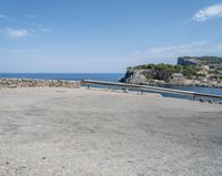 a paved road beside some large boats and a bridge with a bridge to the water