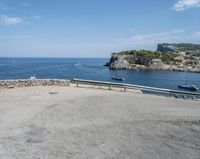 a paved road beside some large boats and a bridge with a bridge to the water