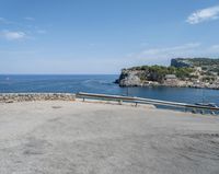 a paved road beside some large boats and a bridge with a bridge to the water