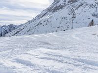 a person on skis is heading down a slope in the snow with mountains in the background