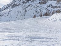 a person on skis is heading down a slope in the snow with mountains in the background