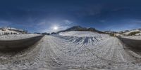 the panorama angle for the snow covered slope and road is distorted by the large lens