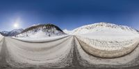 a mountain range with a view of a sun and snow covered ground, in full color