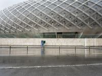 a very big building that has a metal structure next to it and a blue box with holes