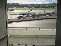 an airport runway from inside a building looking outside at an airplane taking off from it's landing strip