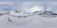 the view through the snow of mountains, where there is snow on the ground and a person standing on snow board