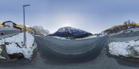 two 360 - zoom pictures with an entire road and a mountain covered in snow and a street light