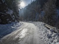 a snowy road in the mountains with a bench along the road, under a sky filled with clouds