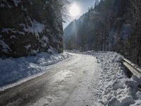a snowy road in the mountains with a bench along the road, under a sky filled with clouds