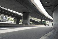 a road underpass with an overpass in the background and a building in the background