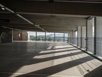 a corridor with many windows and signs in the sunlight behind them, with an empty walkway leading up to a window