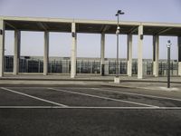 parking lot with a concrete structure with light poles, benches and traffic lights on the ground