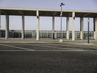 parking lot with a concrete structure with light poles, benches and traffic lights on the ground